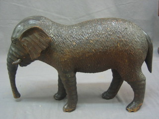 A carved Eastern wooden figure of a  walking elephant 12"