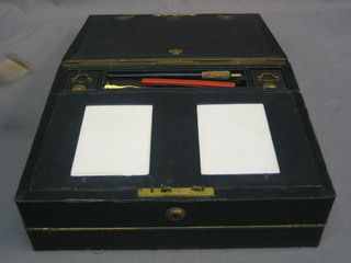 A Victorian black leather writing slope the interior fitted 2 ink bottles by Parkins & Cotta