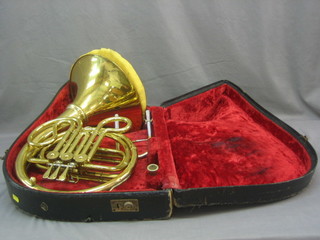 A brass French horn, cased