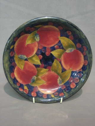 A Moorcroft pottery circular plum patterned plate, the reverse impressed Moorcroft, having a Moorcroft signature and with paper label 9"