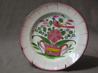 A faience pottery plate decorated a bird (chip to rim) 9"