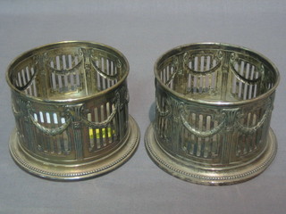 A pair of circular pierced silver plated bottle coasters 4"