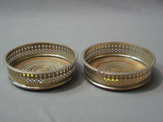 A pair of circular pierced silver plated bottle coasters