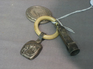A silver cigar cutter, a silver rattle, a teething ring and a silver locket