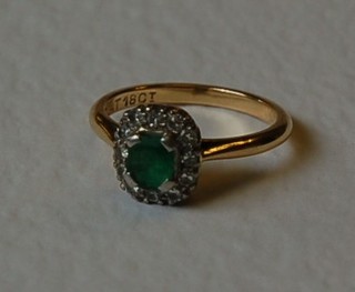 A lady's 18ct gold dress ring set a square cut emerald supported by diamonds