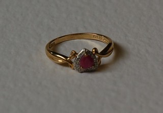 A lady's 9ct gold dress ring set a heart shaped ruby surrounded by diamonds
