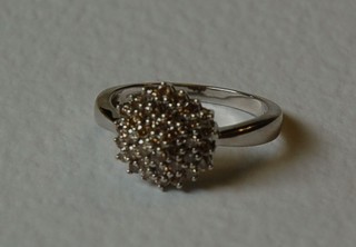 A white gold cluster ring set numerous illusion diamonds