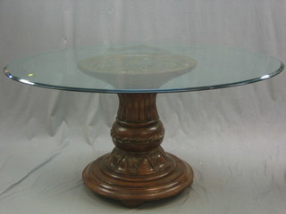 An impressive circular plate glass dining table, raised on a carved and turned mahogany column 58"