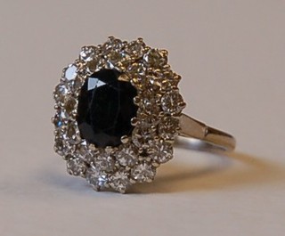 A lady's very attractive 18ct white gold cluster ring set a large oval sapphire surrounded by numerous diamonds, approx 2.25cts
