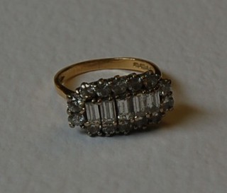 A lady's 18ct gold cluster dress ring set 5 baguette cut diamonds supported by numerous circular cut diamonds