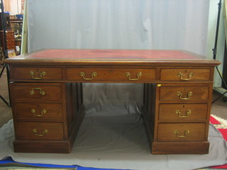 An Edwardian walnut kneehole pedestal desk with inset tooled leather writing surface, above 1 long and 8 short drawers 65"