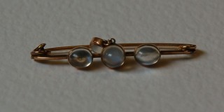 A lady's "gold" bar brooch set 3 cabouchon cut moonstones