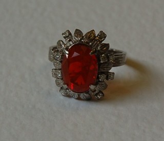 An 18ct gold dress ring set an oval "red opal" surrounded by diamonds