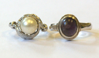A silver dress ring set a cabouchon cut amethyst coloured stone and 1 other set a "pearl"