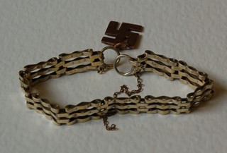 A 9ct gold Swastika pendant and a gilt metal bracelet (2)