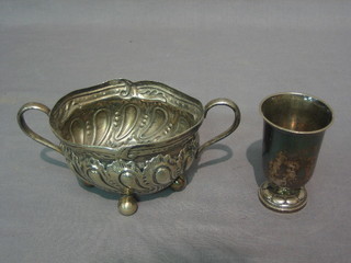 A Continental silver beaker raised on a spreading foot, 2" together with an embossed sugar bowl on bun feet