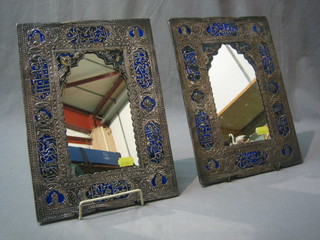 A pair "Qajar" mirrors contained in embossed silver and enamelled frames 12" x 9"