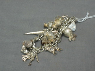 A silver curb link charm bracelet with  padlock clasp and hung 12 various charms, 2 ozs