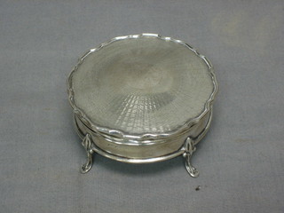 A circular silver dressing table box with hinged lid, raised on turned supports 3", Birmingham 1925