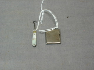 A silver stamp case in the form of an envelope and a small button hook with mother of pearl mount 