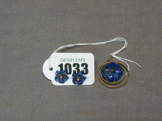 A gold pendant set a caved lapis lazuli in a gold panel and a pair of similar earrings