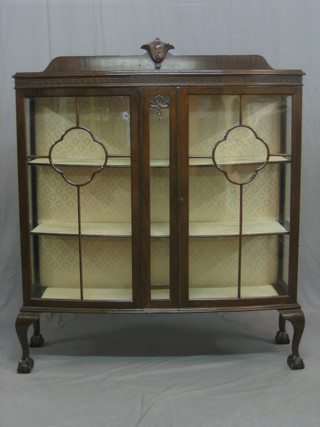 A Chippendale style mahogany display cabinet with carved raised back, the interior fitted shelves enclosed by astragal glazed panelled doors, raised on cabriole ball and claw supports 47"