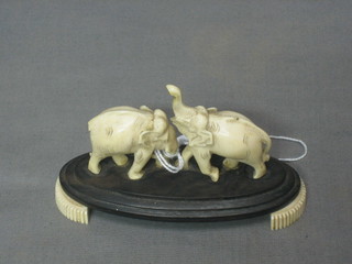 2 carved ivory figures of elephants on an oval base 3"