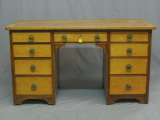 A Victorian honey oak aesthetic movement desk with inset vinyl writing surface and 1 long and 8 short drawers 51"