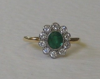 A lady's 18ct yellow gold dress ring set an oval cut emerald surrounded by 10 diamonds approx. 0.45/0.65ct