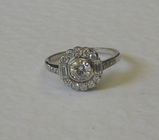 An 18ct white gold cluster dress ring set a large circular cut diamond supported by 2 baguette cut diamonds and 10 small diamonds with 6 diamonds to the shoulder, approx 0.80ct