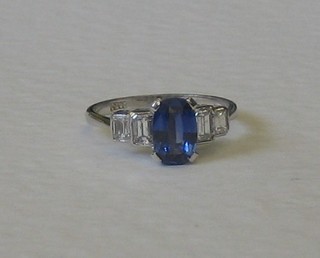 A lady's 18ct white gold dress ring set an oval cut sapphire supported by 4 baguette cut diamonds to the shoulders approx 0.60/1.40ct