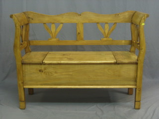 A Continental stripped and polished pine settle with pierced back the seat fitted a hinged lid, 472"