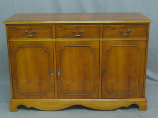 A Georgian style yew sideboard with crossbanded top above 3 long drawers, the base fitted a triple cupboard 47"