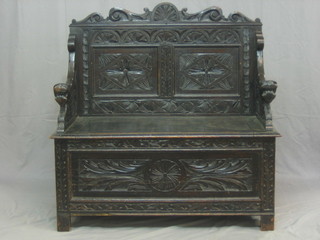 A Victorian carved dark oak settle with hinged lid 40"