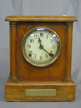 An American 8 day mantel clock with paper dial and Arabic numerals contained in a honey oak case by the Sessions Clock Co.
