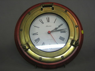 A Quartz, ships style wall clock contained in a mahogany frame in frame in the form of a port hole 12"