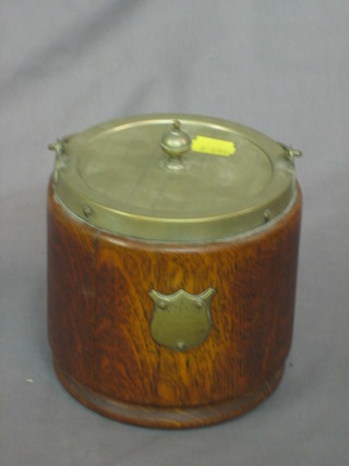 A circular silver plated and oak biscuit barrel