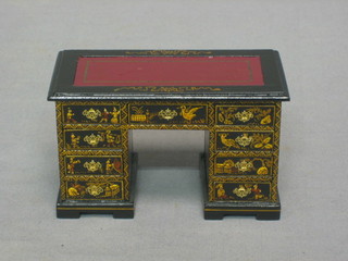 A dolls house black lacquered chinoiserie style kneehole pedestal desk fitted 9 drawers, raised on bracket feet 4 1/2" by Judith Dunger