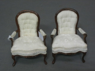 A dolls house pair of mahogany show frame open arm chairs upholstered in white material, raised on cabriole supports