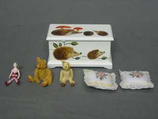 A dolls house white painted ottoman with hinged lid containing 2 cushions, a small dolly and 2 teddybears 3"