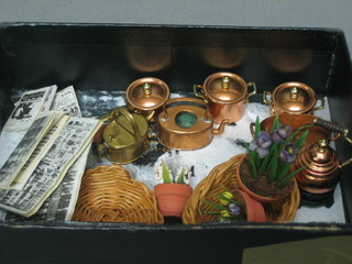 A dolls house oval copper fish kettle, 2 circular lidded saucepans, a kettle, a saucepan, a brass finished hotwater carrier, a kettle bucket (no lid), 3 pot plants, a dog basket, a wicker basket and various miniature books and newspapers