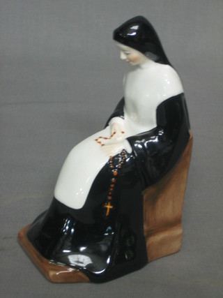A Coalport figure of a seated nun 6"