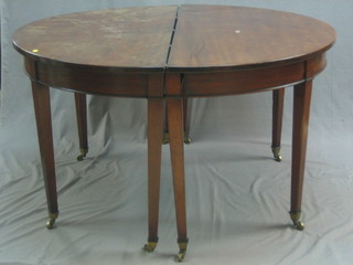 A Georgian mahogany D end dining table with pierced relief, raised on square tapering supports ending in brass caps and castors with 1 extra leaf