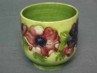 A Moorcroft green glazed cachepot of oval form with anemone, the base impressed Moorcroft Made in England 4"