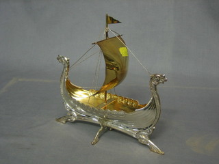 A white metal model of a long boat 8"