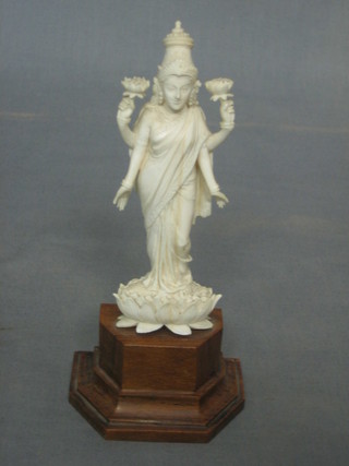 A carved ivory figure of a Deity on a hardwood base 5"