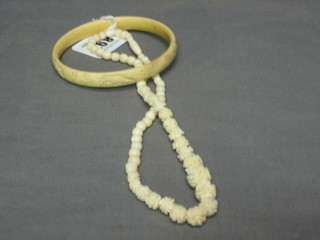 An ivory bangle and a string of ivory beads