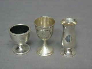 A silver egg cup with engine turned decoration, a Continental embossed silver egg cup and a small Continental silver vase 3"