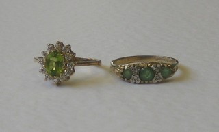 A gold dress ring set 3 green stones supported by 4 diamonds and 1 other gold dress ring set green and white stones