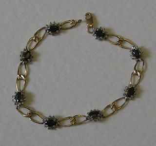 A modern 9ct flat link bracelet set 8 oval cut sapphires surrounded by diamonds
